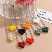 Assorted heart-shaped acrylic necklaces in vibrant colors displayed with silver chains, ideal for couples.